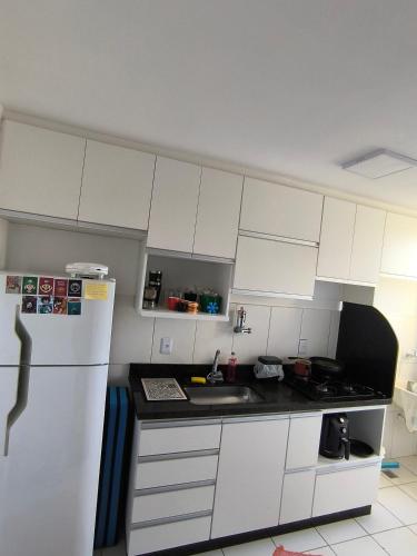 a kitchen with white cabinets and a white refrigerator at Apartamento 1Q 2B com vaga in Aparecida de Goiânia