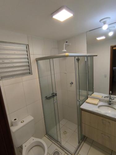 a bathroom with a shower and a toilet and a sink at Apartamento 1Q 2B com vaga in Aparecida de Goiânia