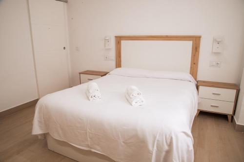 a bedroom with a white bed with two towels on it at Hospedium GL Andújar Boutique in Andújar