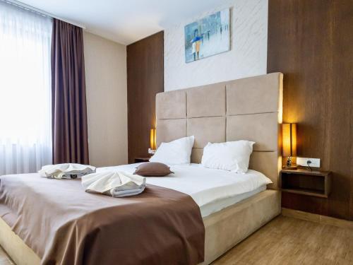 a hotel room with a large bed with white sheets at Hotel Crystal in Pećinci