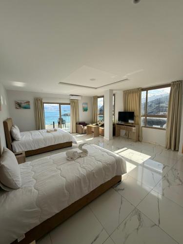 a large bedroom with a large bed and a living room at Golden Bay Hotel in Al Hoceïma