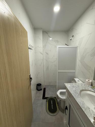 a bathroom with a toilet and a sink and a door at Golden Bay Hotel in Al Hoceïma