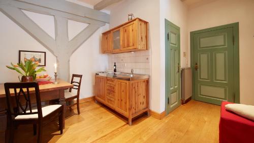 eine Küche mit einem Tisch und eine Küche mit einer grünen Tür in der Unterkunft Altstadt Gästehaus Drewes Wale in Lüneburg