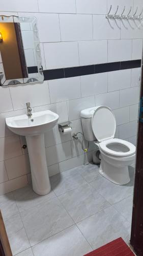 a bathroom with a toilet and a sink at Kent One Hotel in Fort Portal