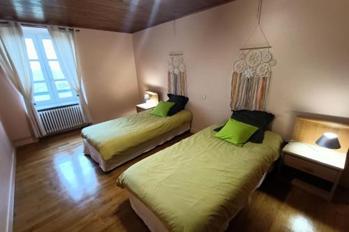 a room with two beds in a room with a window at La bellevue in Lapeyrugue