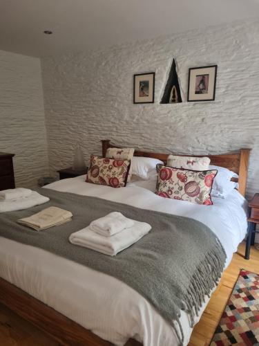 a bedroom with a large bed with towels on it at Owl Barn in Saltash