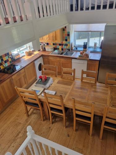 a kitchen and dining room with a table and chairs at Owl Barn in Saltash