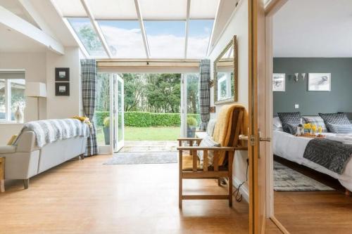 a bedroom with a bed and a couch and a window at Heather Barn in Saltash