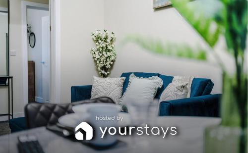 a blue couch with pillows in a living room at Westminster Apartments by YourStays in Crewe