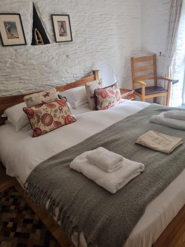 a large white bed with two towels on it at Little Owl in Saltash