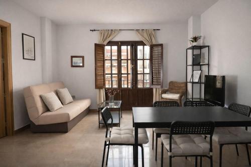 a living room with a couch and a table and chairs at Hospedium GL Andújar Suites in Andújar