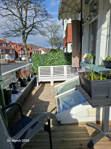 a patio with a bench and a table and a glass table at The Beaches in Scarborough