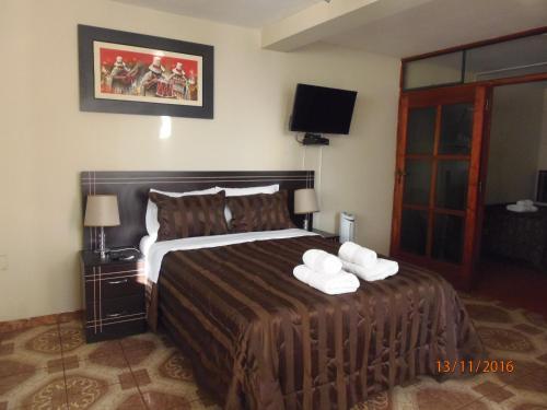 a bedroom with a bed with two towels on it at B&B Cusing Wasi in Lima
