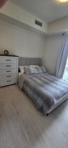 a bedroom with a bed with a dresser and a window at Corner unit 3 bath and 2 bed in Vaughan