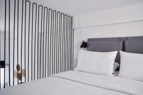 a bedroom with a bed with white sheets and white pillows at Mr and Mrs White Oia - Santorini in Oia
