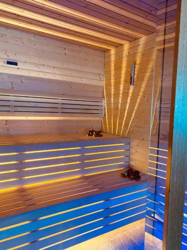 a sauna with two shoes sitting on a wooden bench at Alps Oriental Wellness HOTEL in Campodolcino