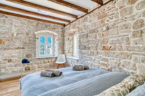 a stone walled bedroom with a bed in a room at Stunning Views & Hidden Terraces Above the Old Town in Kotor