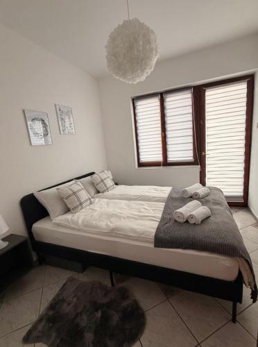 a bedroom with a bed with two towels on it at Levendula Apartman in Bačka Topola