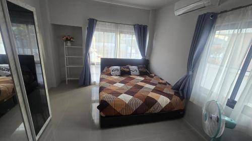 a bedroom with a bed in the corner of a room at joyful House Naiyang 238 in Nai Yang Beach