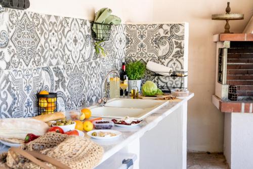 a kitchen counter with a sink and fruits and vegetables at Villa Argias Halikounas in Halikounas