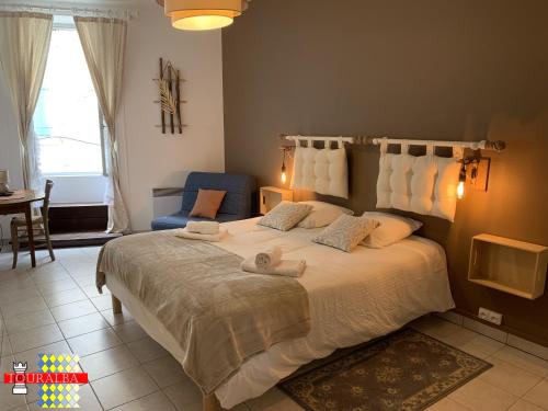 a bedroom with a large bed with towels on it at Echoppe Ancienne Boutique de cordonnier avec jardin privé in Aubeterre-sur-Dronne