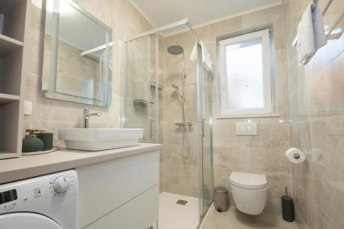 a bathroom with a shower and a sink and a toilet at Apartman Turcic in Malinska