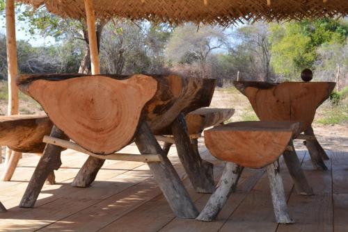 a wooden table and chairs sitting under an umbrella at Yala Dream Park in Yala