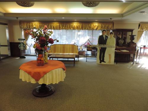 two people standing in a room with a table with flowers at Hotel Grand Terrace Sendai Kokubun-cho in Sendai