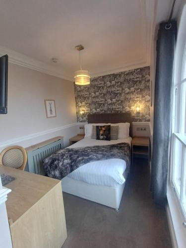 a bedroom with a bed and a brick wall at Fox and Pheasant Inn in Armathwaite