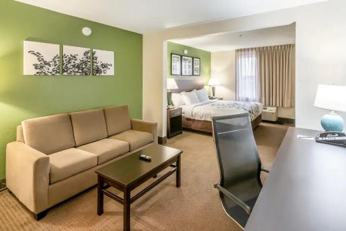 a hotel room with a couch and a bed at Sleep Inn & Suites Ruston Near University in Ruston