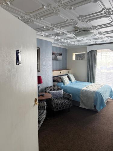 a bedroom with a bed and a couch and a chair at Castle By The Sea Scarborough in Scarborough