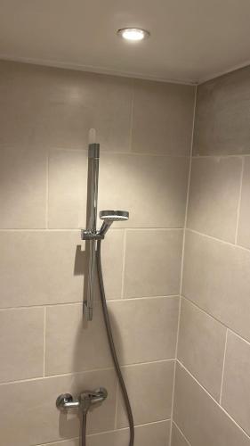 a shower with a hose in a bathroom at La Boulangerette - Studio in Kralingen in Rotterdam