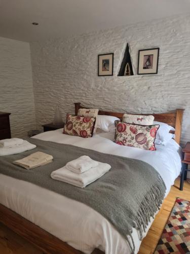a bedroom with a large bed with towels on it at The Roost in Saltash