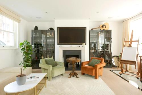 a living room with a tv and a fireplace at Haus of Timon Victorian Elegance near Olympia in London