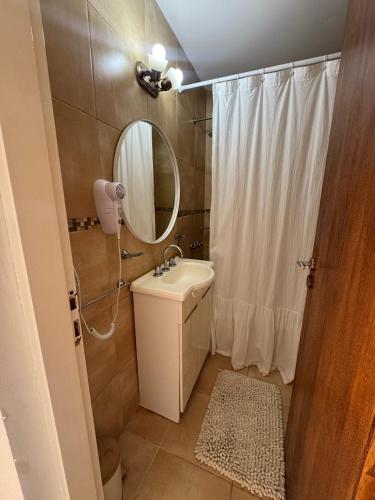 a bathroom with a sink and a mirror and a shower at Duplex Moderno en Chascomus in Chascomús