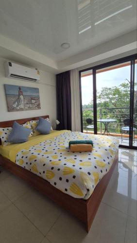 a bedroom with a bed with a yellow and white comforter at PB326 Beautiful studio in Phuket in Ban Mai Salae
