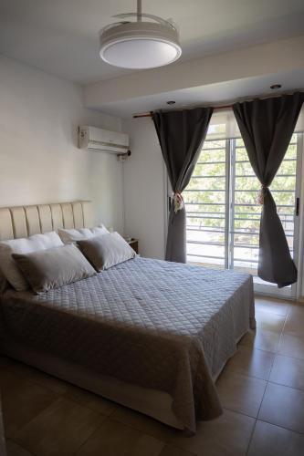 a bedroom with a large bed and a large window at Duplex Moderno en Chascomus in Chascomús