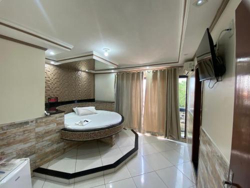 a bathroom with a bath tub and a sink at Hotel Master Blue - Brasília in Ceilândia