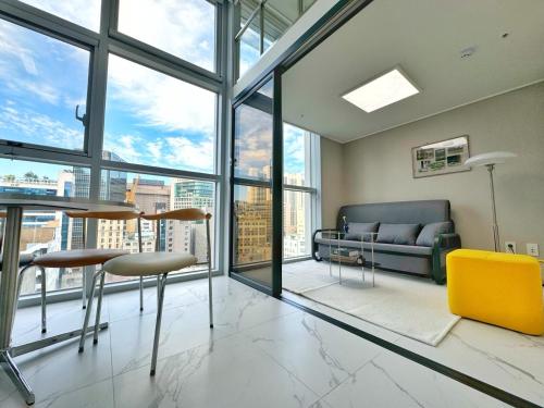 a living room with a couch and a table and chairs at The Comfort in Seoul