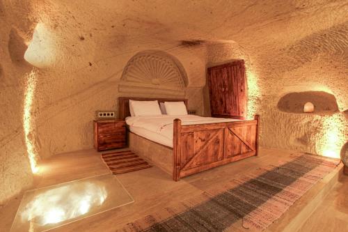 a bedroom with a bed in a stone room at Babili Cappadocia Cave in Nevşehir