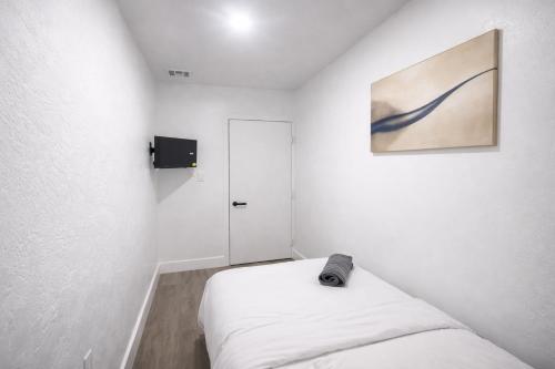 a white room with a bed and a painting on the wall at Fort Lauderdale Airport Bleu Lagunna in Hollywood