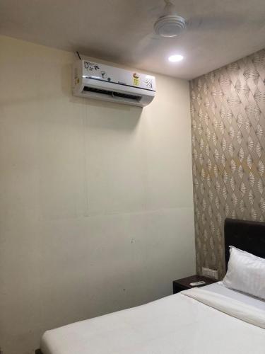 a room with two beds and a air conditioner on the wall at Hotel Grants Residency Colaba in Mumbai