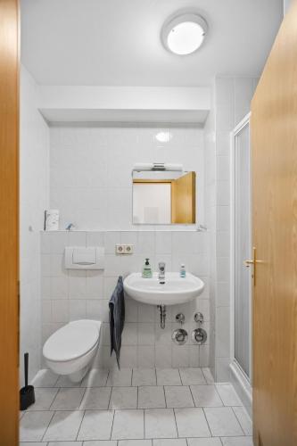 a white bathroom with a sink and a toilet at Moderne Einraumwohnung in Leipzig mit Netflix Zugang in Leipzig