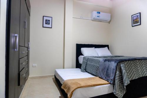 a small bedroom with a bed and a refrigerator at Espacio Ideal 101 in Yopal