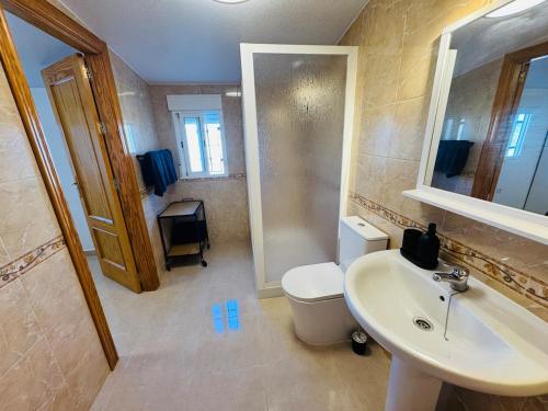a bathroom with a sink and a toilet and a mirror at Casa Indigo Mazarron in Mazarrón