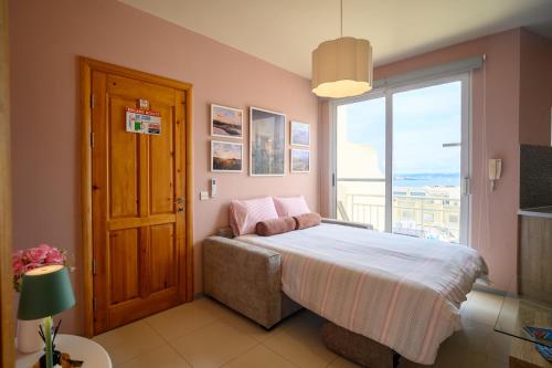 a bedroom with a bed and a large window at Il-Kannizzata luxurious Gozo penthouse with sea view & pool in Għajnsielem