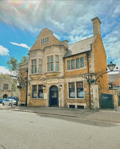 an old brick building on the corner of a street at The Red Lion Inn in Rothwell