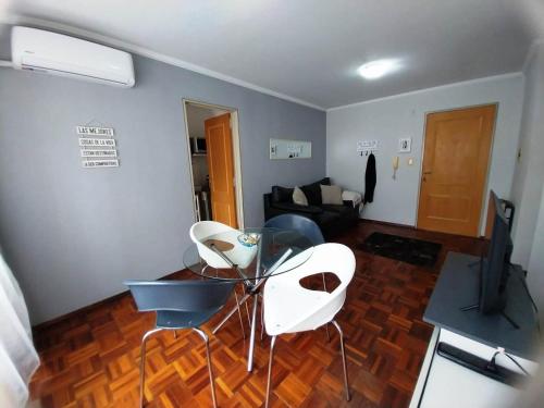 a living room with a glass table and white chairs at Departamento CBA in Córdoba