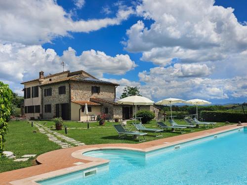 a villa with a swimming pool in front of a house at Podere Raggio Di Sole in San Gimignano