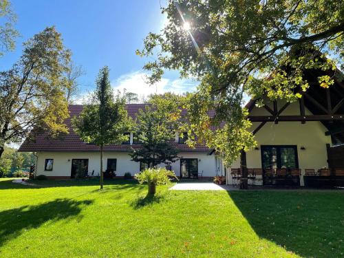 a house with a green yard in front of it at Baumhaus Baum 4 in Burg